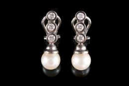 PENDIENTES LARGOS DE BRILLANTES, PERLAS CULTIVADASD Y ORO BLANCO Realizados en oro blanco de 18 kt., formados por una hilera de 3 diamantes talla brillante engastados en chatón, peso total aproximado: 0.70 ct., rematados en una perla cultivada cada uno, c