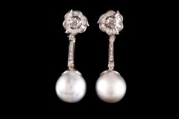 PENDIENTES LARGOS DE DIAMANTES, PERLAS TAHITÍ Y ORO BLANCO Realizados en oro blanco de 18 kt., parte superior con motivo floral formado por diamante central talla brillante engastado en garras, orlado por carril de diamantes talla baguette, del que pende