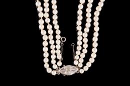 COLLAR DE PERLAS CULTIVADAS Y BROCHE EN ORO BLANCO De tres vueltas, formado por perlas cultivadas calibradas entre 5 y 8 mm. Cierre realizado en oro blanco de 18 kt., con una circonita central engastada en chatón con grapas y 6 circonitas engastadas en gr