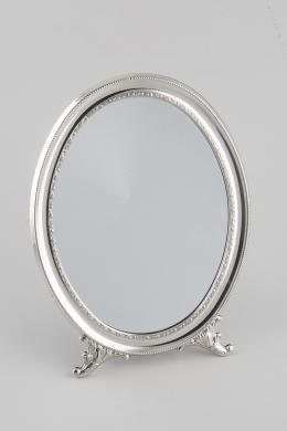 MARCO Realizado en plata en su color, de forma ovalada, decorado con motivos vegetales, cenefa de contario y patas de apoyo. Espejo. Contraste: 925. Medidas: 29 x 22 cm.