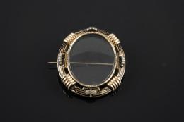 BROCHE PORTAFOTOS Realizado en oro de 14 Kt. con decoración geométrica esmaltada en color negro y perlas de aljófar.