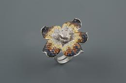 SORTIJA Realizada en plata en su color, representando una flor con pétalos abiertos, cuajada de piedras de color y piedras de imitación.