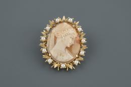 BROCHE Realizado en oro, con camafeo central representando el rostro de una mujer acompañado por perlas cultivadas calibradas en 3 mm.