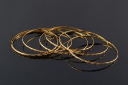 SEMANARIO Realizado en oro liso y matizado, compuesto por siete pulseras rígidas.