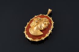 COLGANTE Realizado en oro bajo, contorno polilobulado, formado por un jaspe rojo con una  mujer de perfil, tocada con flores y diamantes talla 8/8, peso total aproximado: 0.21 ct.