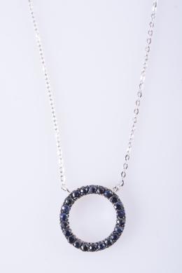 COLGANTE DE ORO BLANCO Y ZAFIROS Realizado en oro blanco de 18kt. Compuesto por un colgante circular cuajado de zafiros talla redonda, engastados en garras, con un peso total aproximado: 1.20ct. Cadena con sistema cierre de reasa. 