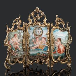 RELOJ DE SOBREMESA, FINALES S.XIX Tríptico con marco de latón estilo neobarroco con esmalte Viena representando escenas de baño mitológicas. Reloj central con esfera blanca, numeración romana para las horas y arábiga para los minutos y agujas doradas. Mov
