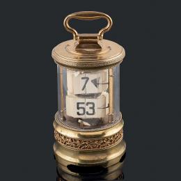 RELOJ DE CARRUAJE FRANCÉS C.1900 Primer reloj "digital". Diseño cilíndrico en metal dorado y la parte central en cristal, en cuyo interior van dispuestas placas de  con números arábigos, las superiores para horas, las inferiores para minutos, movimiento d