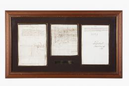 Tres manuscritos enmarcados juntos: Uno firmado por Carlos I, otro por el Cardenal Cisneros y otro por Carlos III