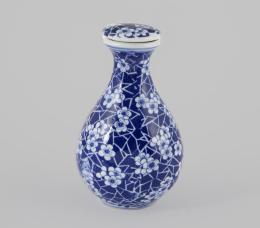 JARRONCITO CON TAPÓN EN PORCELANA ESMALTADA Y VIDRIADA FAMILIA AZUL Y BLANCA. MARCA EN LA BASE. SIGUIENDO MODELOS DE LA DINASTÍA QING, CHINA