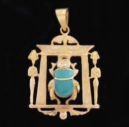 COLGANTE CON ESCARABAJO EN ORO AMARILLO 18 KT Realizado en oro amarillo de 18 kt. De inspiración egipcia, representando la entrada de un templo con un gran escarabajo azul central.