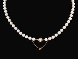 COLLAR DE PERLAS CON BROCHE EN ORO AMARILLO 18 KT Formado por una vuelta de perlas cultivadas calibradas en aprox 7 mm.de diámetro. Broche realizado en oro amarillo de 18 kt, diseño circular con decoración estriada con una perla central cultivada calibrad
