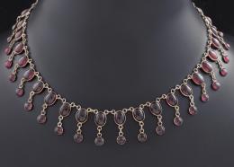 GARGANTILLA CON CABUJONES DE GRANATES EN PLATA Realizada en plata. Formada por cabujones de granates en talla oval y redonda. Cierre de mosquetón.