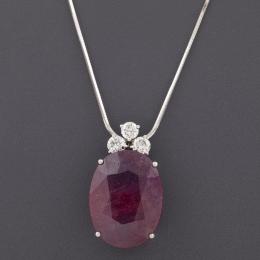 COLGANTE CON CADENA CON RUBÍ Y DIAMANTES EN ORO DE 18 KT Realizada en oro de 18 kt, con contraste. Formada or un gran rubí en talla oval facetada, con un peso aproximado de 25 ct, acompañado por tres diamantes en talla brillante engastados en garras, con