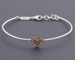 PULSERA RÍGIDA CORAZÓN CON DIAMANTES EN ORO 18 KT Realizada en oro de 18 kt con contrastes. Con detalle central de corazón en metal dorado orlado por pequeños diamantes. Cierre de cadena con mosquetón.