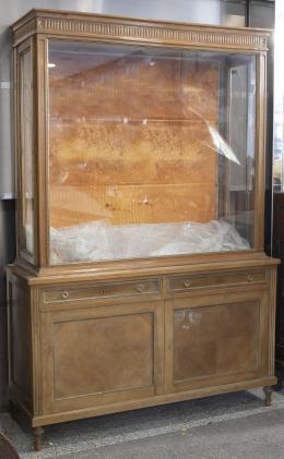 VITRINA ESTILO LUIS XVI Vitrina de madera con espacio para dos baldas en la parte superior. Sólo hay una balda de cristal. Iluminación cenital eléctrica.Cuerpo inferior compuesto por dos cajones y compartimento con puertas y dos baldas. Con llave. (En caj
