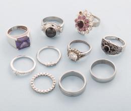 LOTE DE DIEZ ANILLOS DE METAL PLATEADO  conjunto de diez anillos en metal plateado, anillo le falta una piedra incolora.