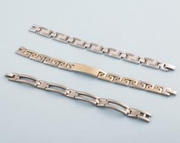 LOTE DE TRES PULSERAS DE ACERO Y TITANIO. conjunto de dos pulseras de acero de stainless steel, y otra de titanio.