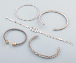 LOTE DE CINCO PULSERAS DE METAL PLATEADO Y ACERO. conjunto de cinco pulseras de metal plateado.