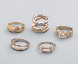 LOTE DE 5 ANILLOS DE METAL DORADO. conjunto de cinco anilos de metal dorado, tres con piedras incoloras.