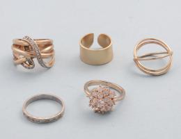 LOTE DE 5 ANILLOS DE METAL DORADO. conjunto de cinco anilos de metal dorado, uno en metal plateado con piedras incoloras, dos con piedras incoloras de metal dorado.