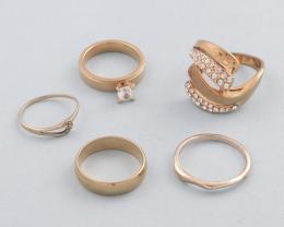 LOTE DE 5 ANILLOS DE METAL DORADO. conjunto de cinco anilos de metal dorado, solitario con piedra incolora, anillo con luna, anillo estilo alianza, anillo con piedras incoloras y anillo sencillo .