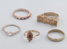 LOTE DE 5 ANILLOS DE METAL DORADO. conjunto de cinco anillos de metal dorado, solitario con piedra incolora, anillo estilo alianza, anillo estilo media alianza con piedras , anillo con motimos decorativos con piedras incoloras y anillo estilo sello .