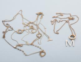 LOTE DE CUATRO CADENAS EN METAL DORADO. conjunto de cuatro cadenas realizadas en metal dorado, cadena de la marca "Purificación García" con colgante redondo e inicial M en color plateado con piedra incolora, cierre de mosquetón, cadena con colgante en for