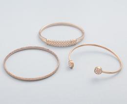 LOTE DE TRES PULSERAS RÍGIDAS EN METAL COBRIZO. conjunto de tres pulseras rígidas en metal cobrizo, dos pulseras con piedras incoloras y una rígida. 
