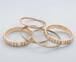 LOTE DE CINCO PULSERAS RÍGIDAS EN METAL DORADO. conjunto de cinco pulseras rígidas en metal dorado, dos pulseras con piedras de colores, dos rígidas, una con piedras incoloras. 