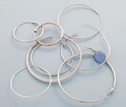 LOTE DE NUEVE PENDIENTES EN METAL PLATEADO. conjunto de nueve pendientes, ocho estilo aro y uno con piedra azul.