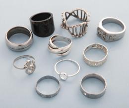 LOTE DE DIEZ ANILLOS DE METAL PLATEADO  conjunto de diez anillos en metal plateado, dos en estado de deterioro, a uno le falta una piedra.