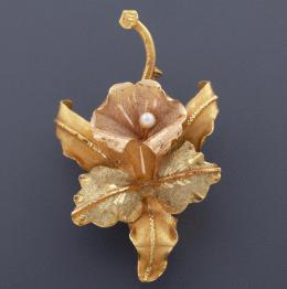BROCHE EN ORO 18 KT EN FORMA FLORAL CON PEQUEÑA PERLA CENTRAL  broche realizado en oro de 18 kt realizadondo motivo floral, acompañado por una perla