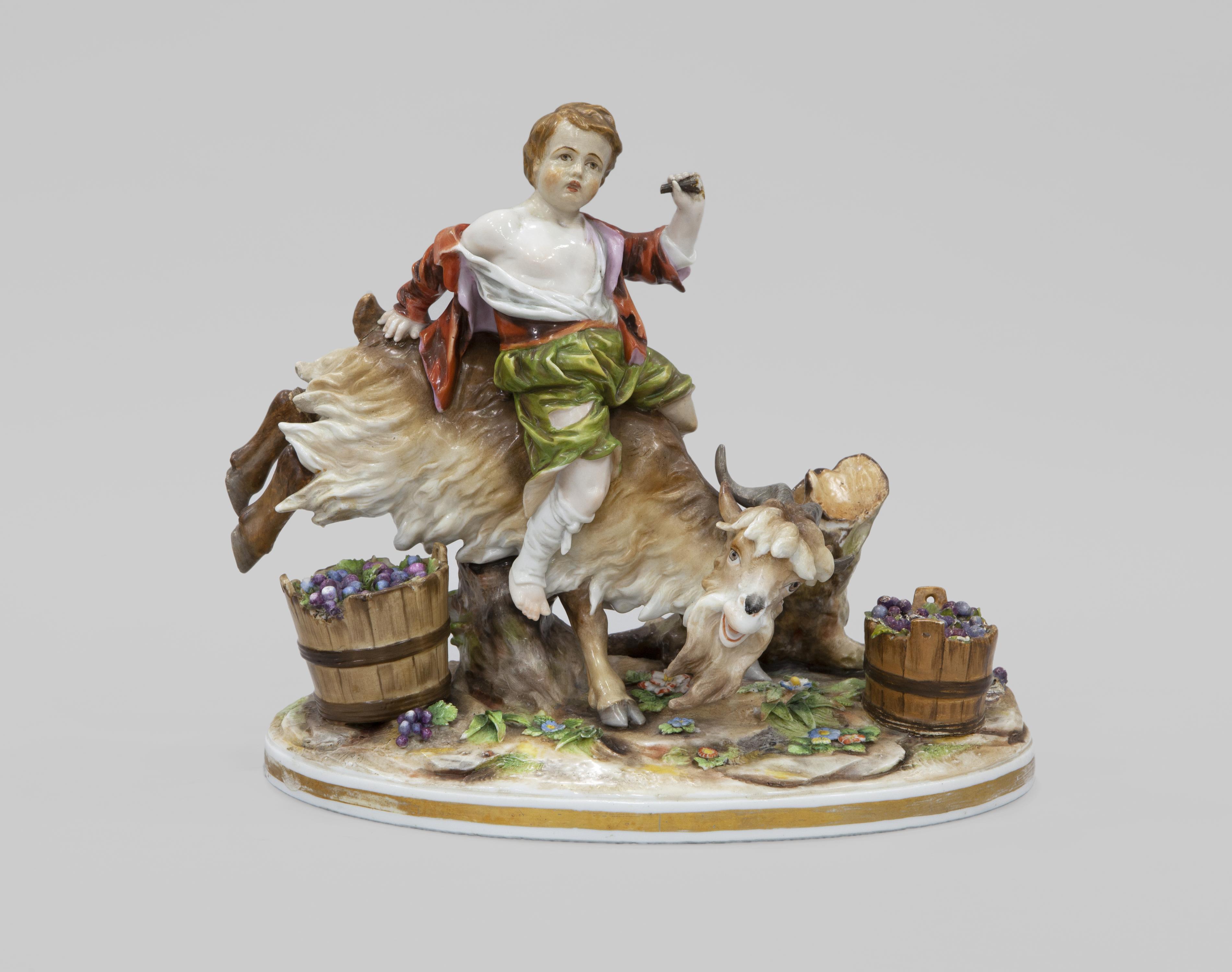 FIGURA DE NIÑO SOBRE CABRA EN PORCELANA