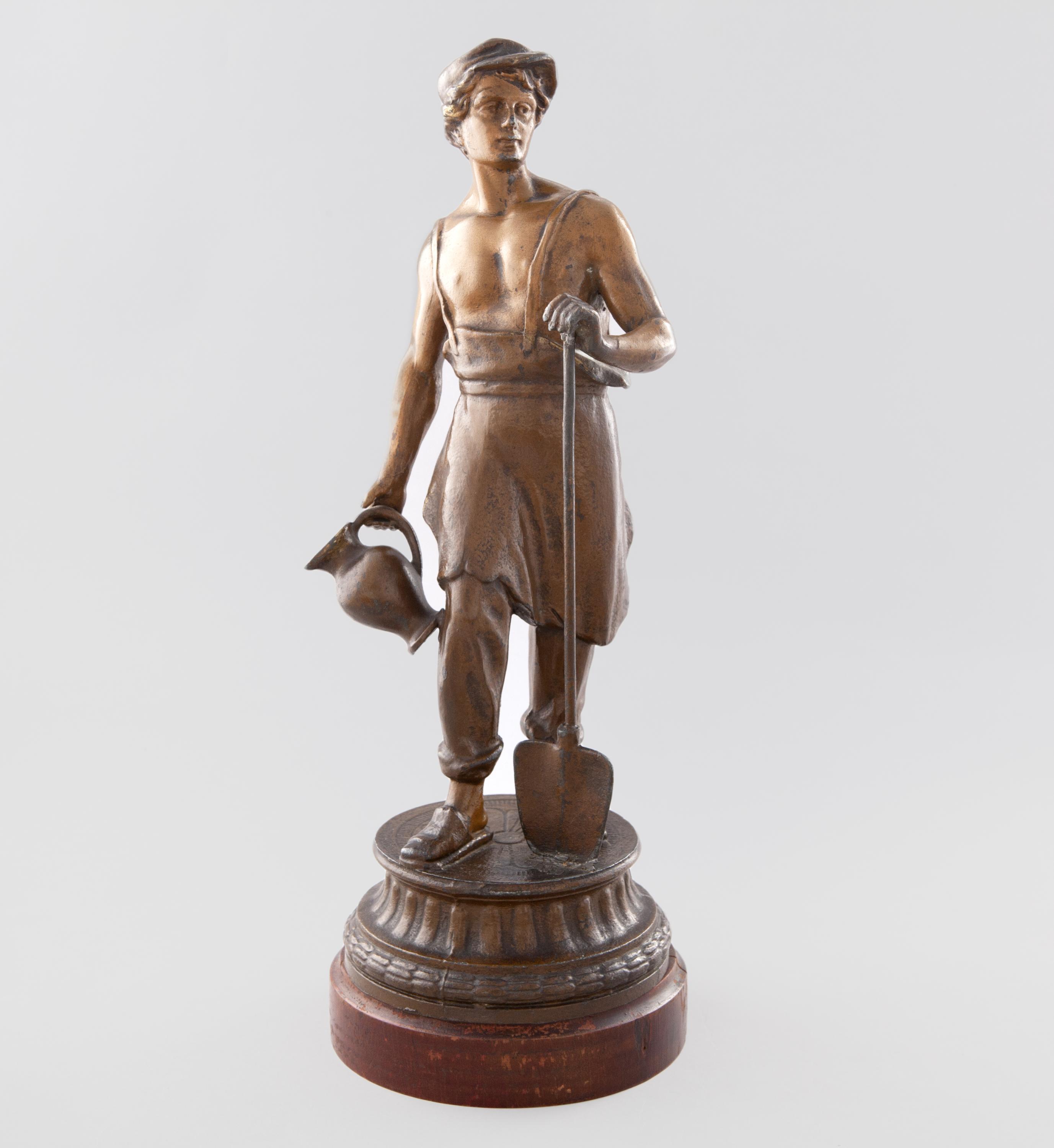 FIGURA DE OBRERO CON PALA  DE CALAMINA PATINADA SOBRE BASE
