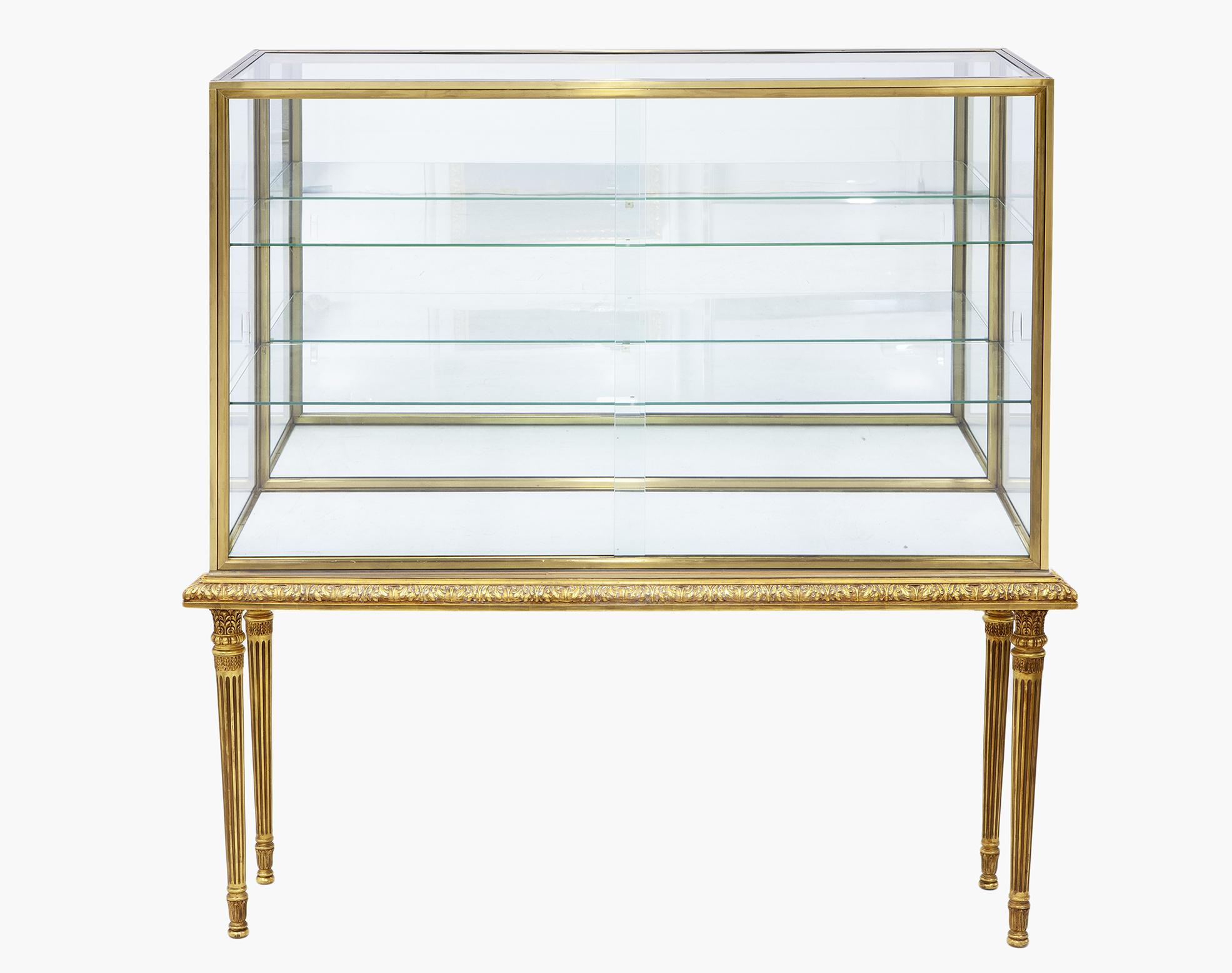 CONSOLA DE MADERA CON VITRINA DE CRISTAL Y METAL DORADO.