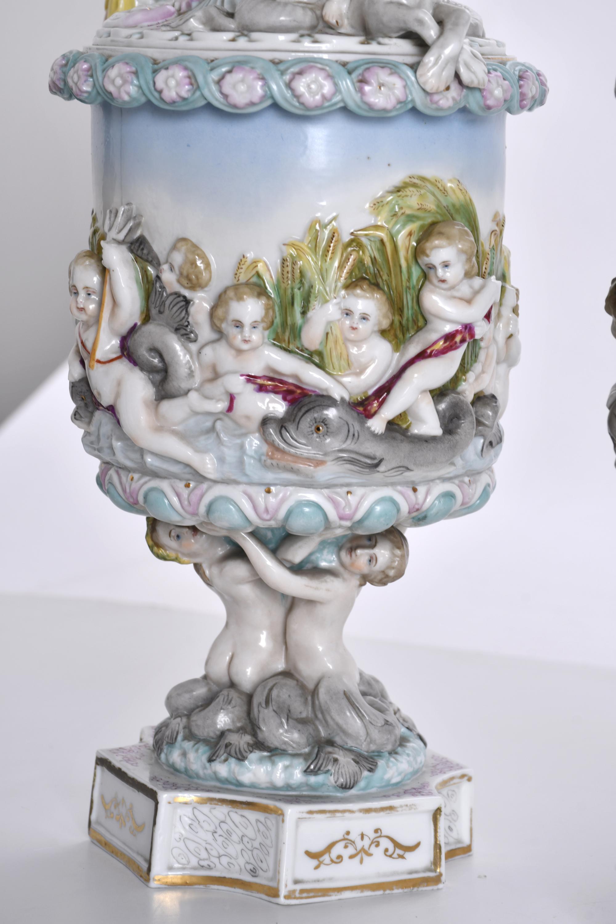 Pareja de jarras y copa en porcelana tipo Capodimonte, sigl